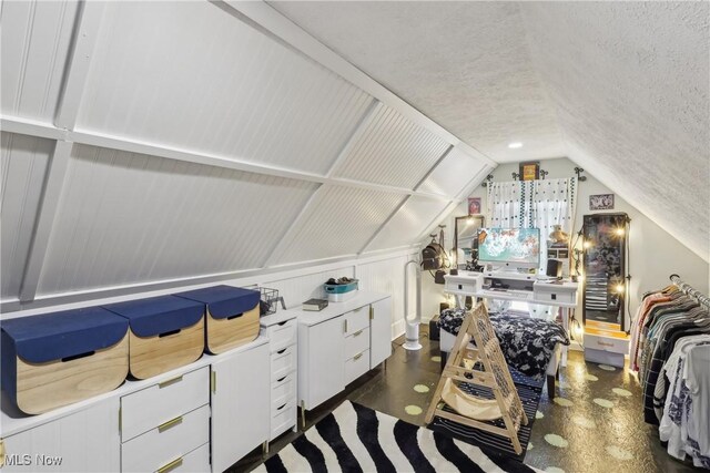 interior space featuring a textured ceiling and vaulted ceiling