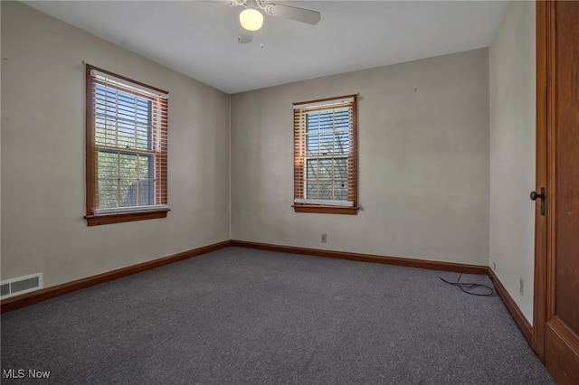 empty room with carpet floors, baseboards, visible vents, and a wealth of natural light