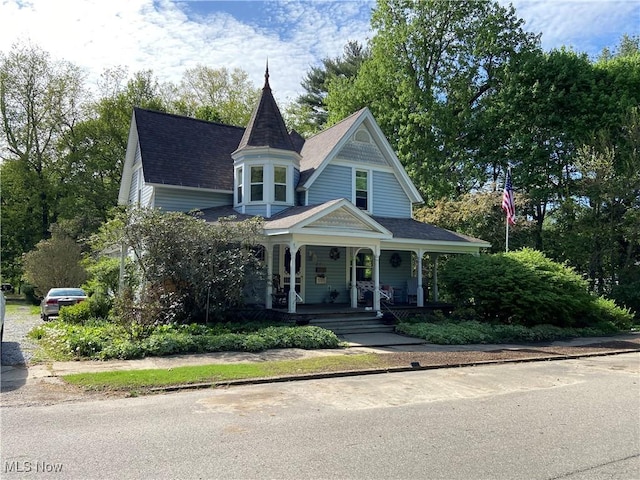 victorian home with roof with shingles and covered porch