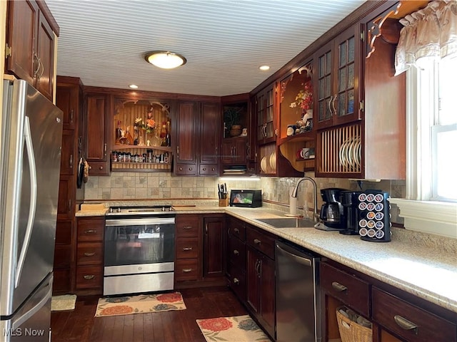 kitchen featuring open shelves, dark wood-style flooring, light countertops, a sink, and stainless steel appliances