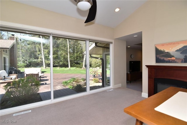 interior space featuring a healthy amount of sunlight, ceiling fan, carpet flooring, and lofted ceiling