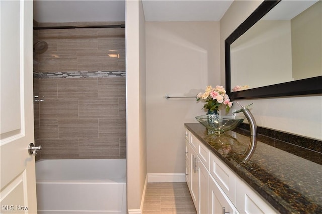 full bathroom featuring baseboards, bathtub / shower combination, and vanity