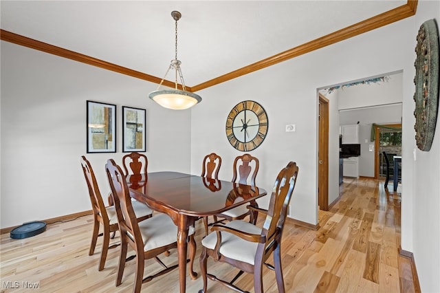 dining room with light wood-style floors, baseboards, and ornamental molding