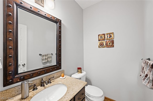 half bathroom featuring toilet and vanity