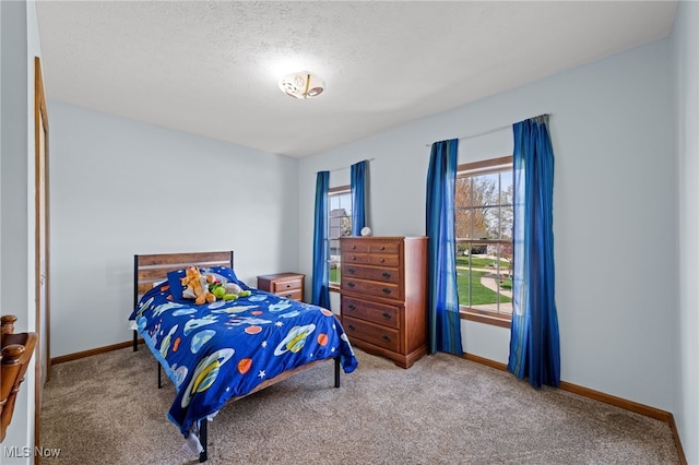 bedroom with carpet flooring, a textured ceiling, and baseboards