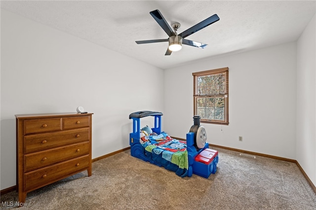 bedroom with a textured ceiling, baseboards, ceiling fan, and carpet