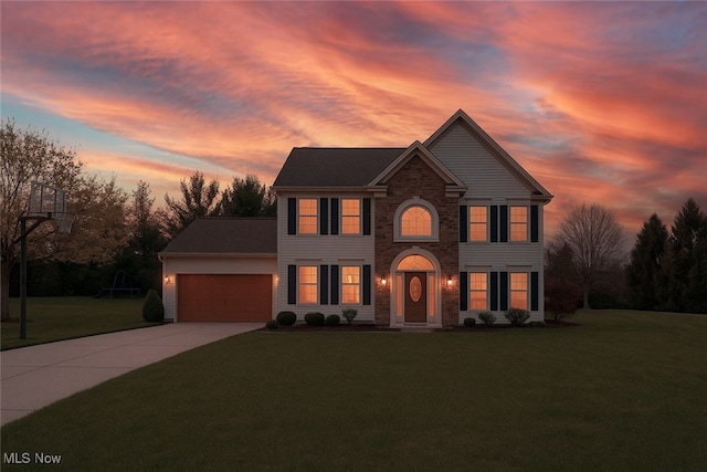 view of front of house featuring an attached garage, a yard, stone siding, and concrete driveway