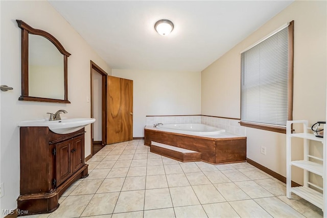 full bathroom with vanity, a garden tub, baseboards, and tile patterned floors