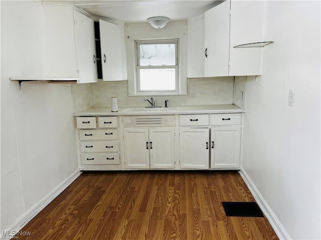 kitchen with light countertops, white cabinets, visible vents, and baseboards