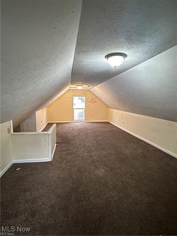 834 Kenyon St, Akron, OH 44311 - bonus room with baseboards, carpet, vaulted ceiling, and a textured ceiling