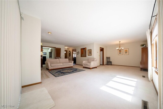 living area featuring light colored carpet, a notable chandelier, and visible vents