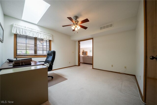 office featuring a ceiling fan, baseboards, visible vents, and light carpet