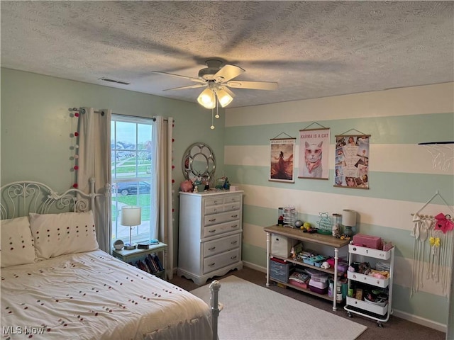 carpeted bedroom featuring a ceiling fan, baseboards, visible vents, and a textured ceiling