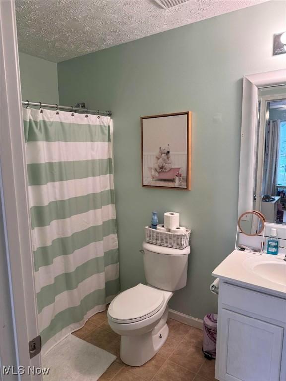 full bath featuring toilet, a textured ceiling, tile patterned flooring, and vanity