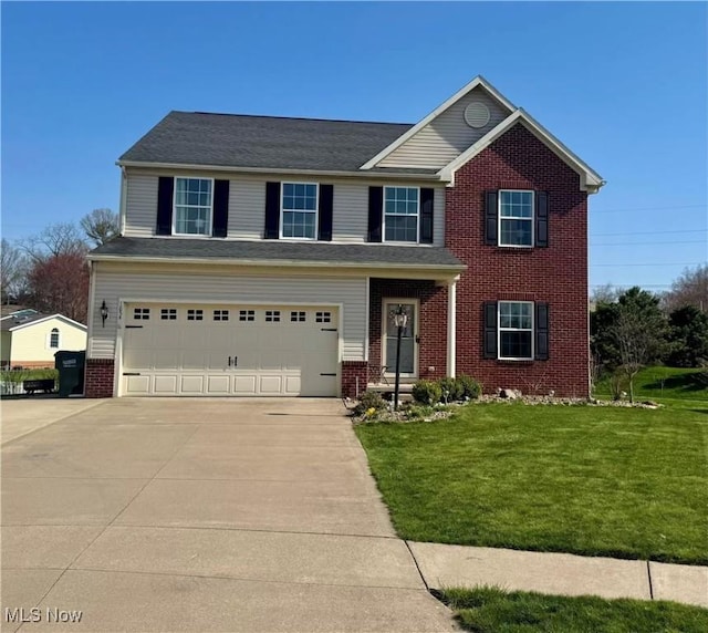 view of front of home with an attached garage, driveway, a front lawn, and brick siding