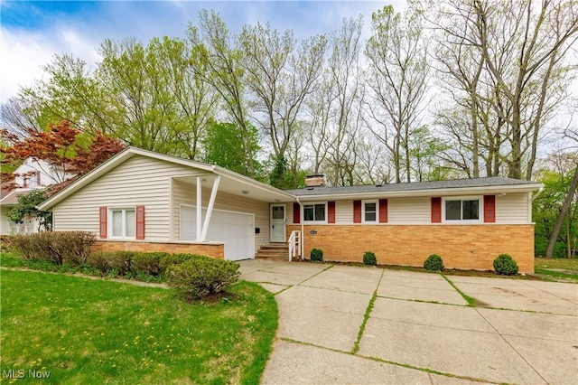view of front of home featuring an attached garage, a front lawn, brick siding, a chimney, and concrete driveway
