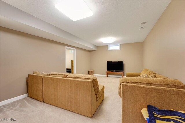 living area featuring baseboards, visible vents, and light carpet