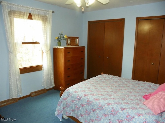 carpeted bedroom with baseboards, a ceiling fan, two closets, and visible vents