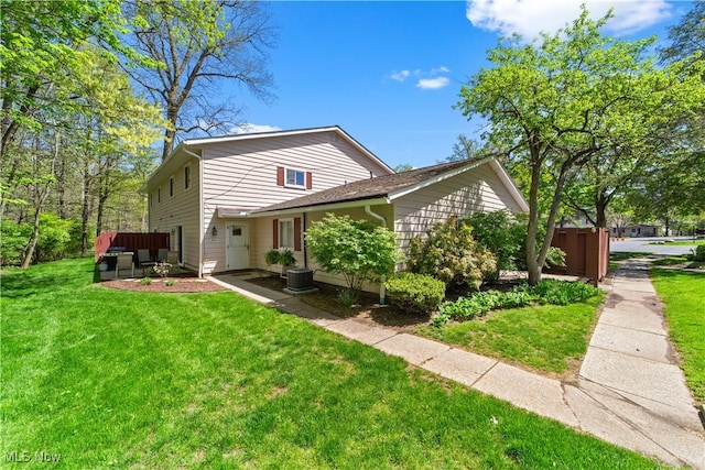 view of front of property with central AC unit and a front yard