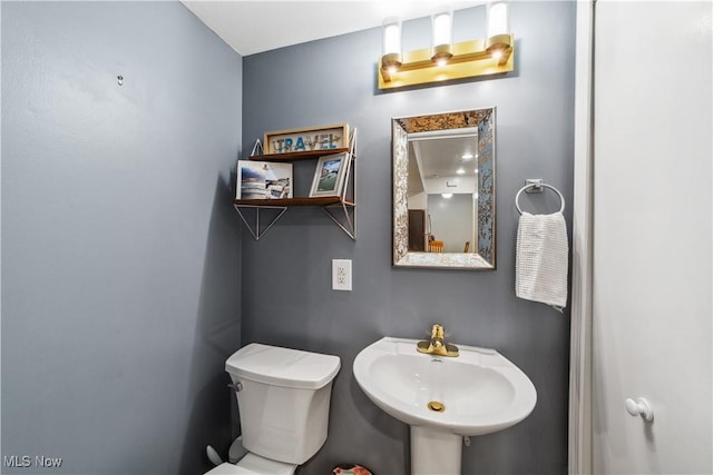 half bathroom with toilet and a sink