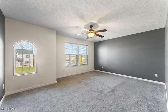 unfurnished room featuring carpet, a textured ceiling, ceiling fan, and a healthy amount of sunlight