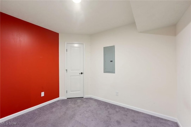 carpeted spare room with baseboards and electric panel