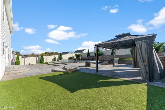 view of yard with a hot tub, a gazebo, a fenced backyard, and a patio area