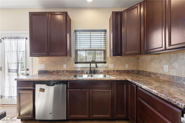 kitchen featuring stainless steel dishwasher, a sink, decorative backsplash, and dark countertops