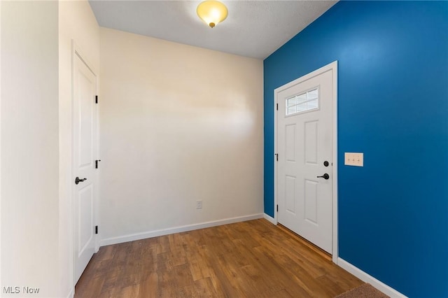 entryway featuring baseboards and wood finished floors