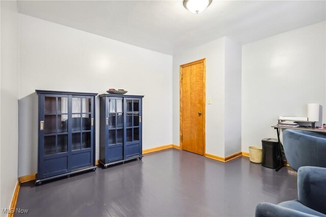 office space with baseboards and concrete floors
