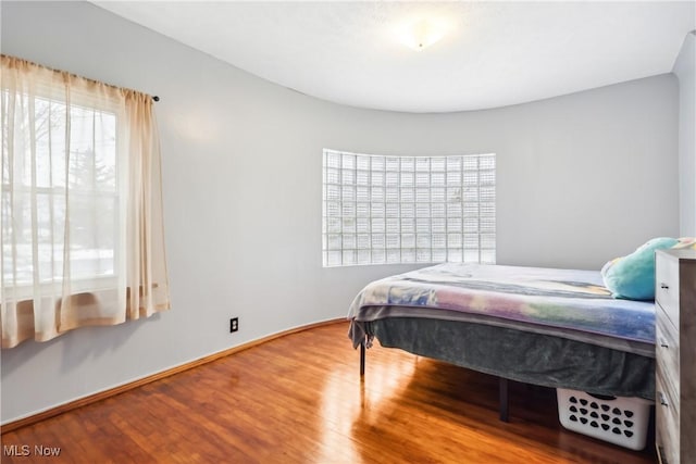 bedroom with baseboards and wood finished floors