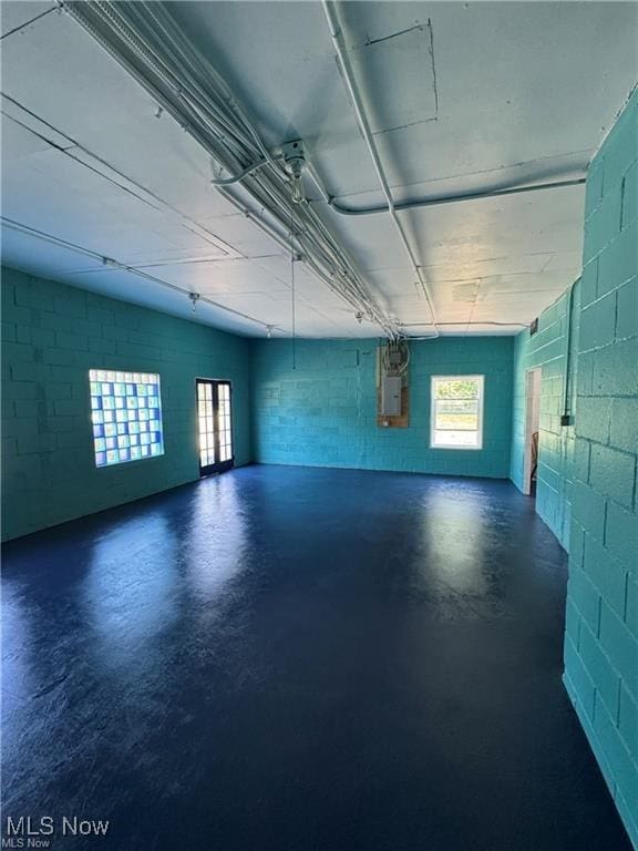 garage with concrete block wall and electric panel
