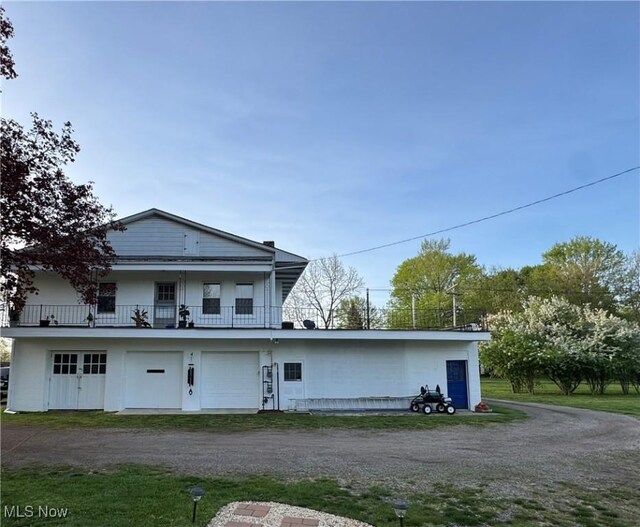 exterior space with a garage, driveway, and a balcony