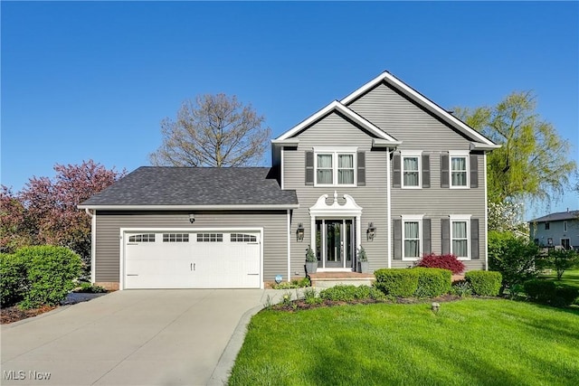 traditional-style home with concrete driveway, an attached garage, and a front lawn