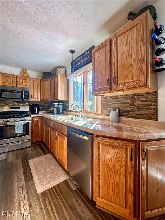 1218 Ohltown Mcdonald Rd, Mineral Ridge, OH 44440 - kitchen with appliances with stainless steel finishes, a textured ceiling, tasteful backsplash, dark wood finished floors, and light countertops