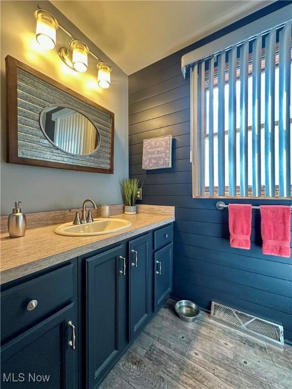1218 Ohltown Mcdonald Rd, Mineral Ridge, OH 44440 - bathroom featuring vanity, wooden walls, and wood finished floors