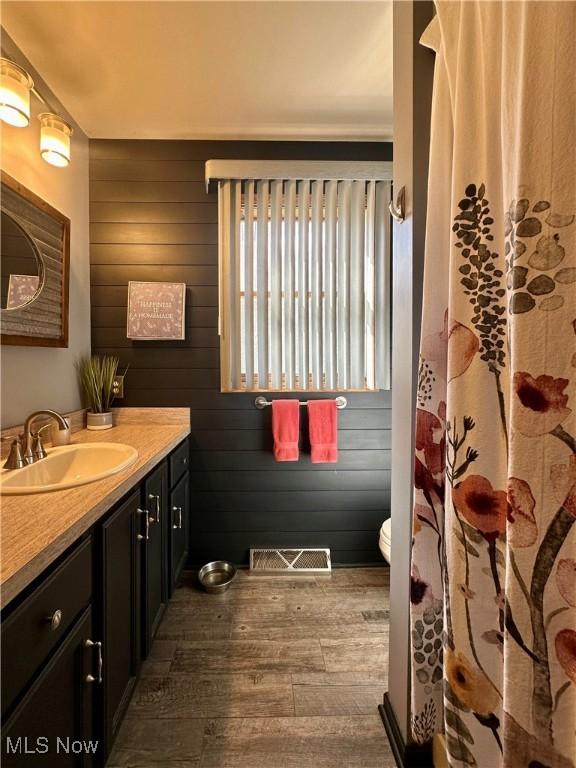 1218 Ohltown Mcdonald Rd, Mineral Ridge, OH 44440 - bathroom with wood-type flooring, vanity, and wooden walls