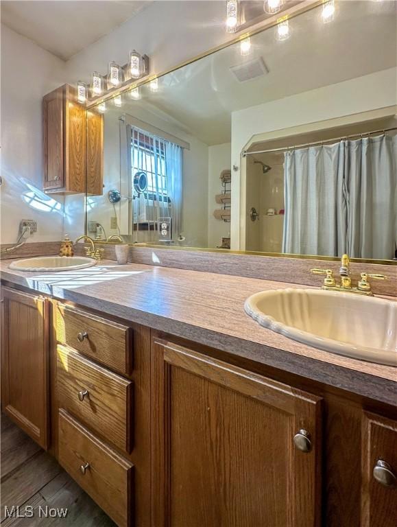 bathroom featuring vanity, curtained shower, and wood finished floors