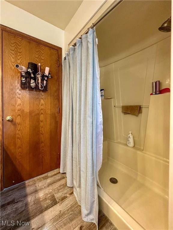 bathroom featuring a shower with curtain and wood finished floors