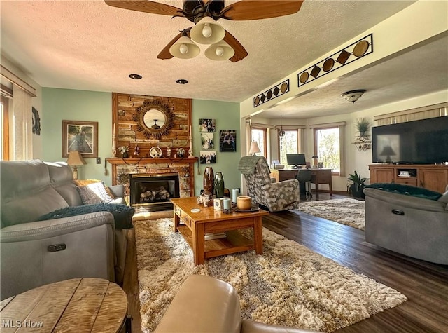 1218 Ohltown Mcdonald Rd, Mineral Ridge, OH 44440 - living area with a textured ceiling, a ceiling fan, dark wood finished floors, a fireplace, and a desk