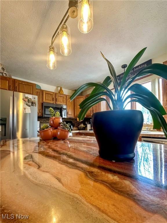 1218 Ohltown Mcdonald Rd, Mineral Ridge, OH 44440 - detailed view of stainless steel appliances, a textured ceiling, and backsplash