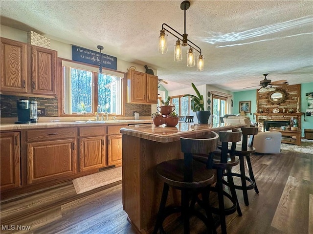 1218 Ohltown Mcdonald Rd, Mineral Ridge, OH 44440 - kitchen with a textured ceiling, dark wood-style floors, a ceiling fan, backsplash, and a kitchen island