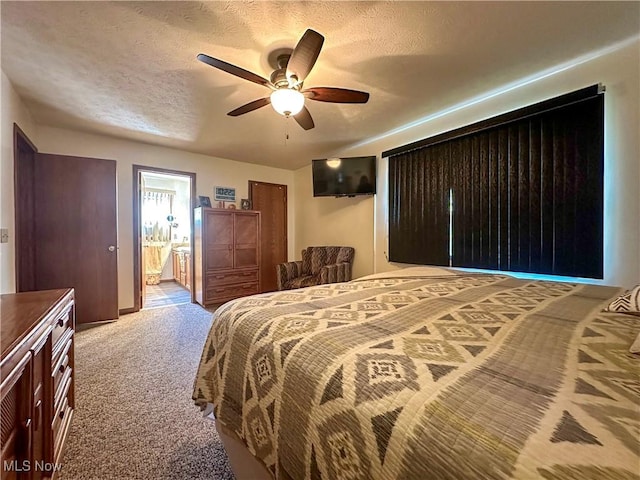 bedroom featuring connected bathroom, a textured ceiling, carpet, and a ceiling fan