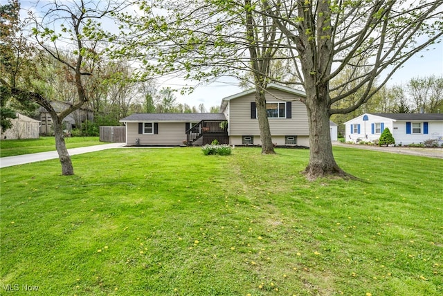 view of front of property featuring fence, driveway, and a front yard