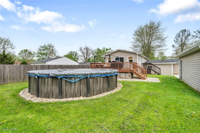 view of yard featuring a fenced in pool, a wooden deck, stairway, and fence