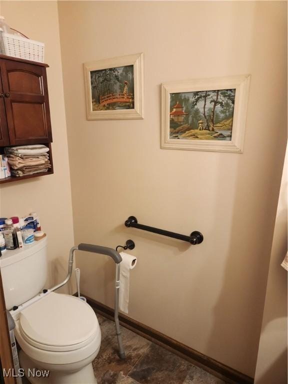 bathroom with baseboards and toilet