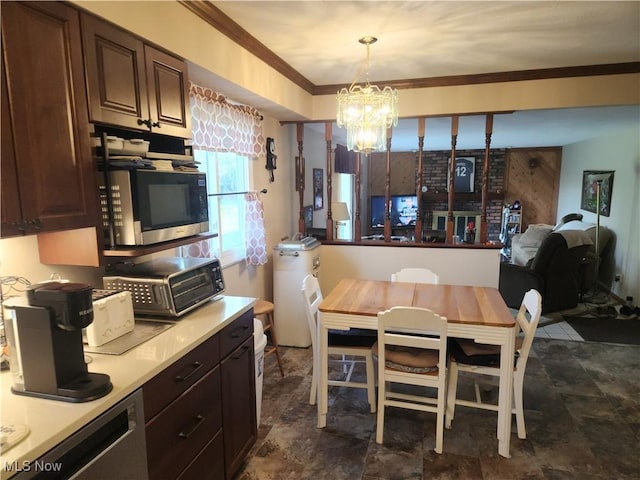 dining room featuring crown molding, a toaster, a chandelier, and stone finish floor