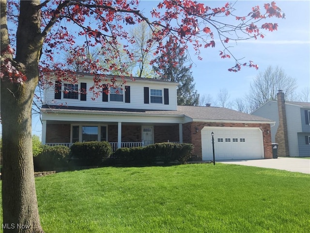 traditional-style house featuring a porch, driveway, a front yard, a garage, and brick siding
