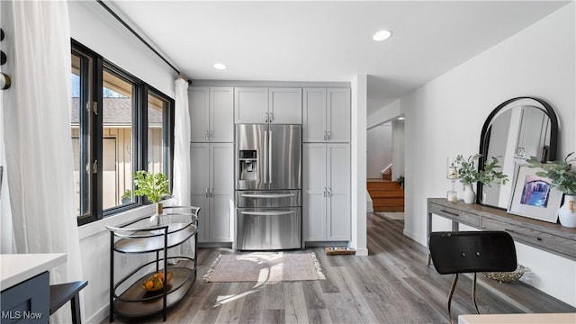 kitchen featuring gray cabinets, baseboards, stainless steel fridge, recessed lighting, and light wood-style flooring