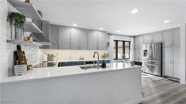 kitchen featuring gray cabinets, open shelves, a peninsula, black electric stovetop, and stainless steel fridge
